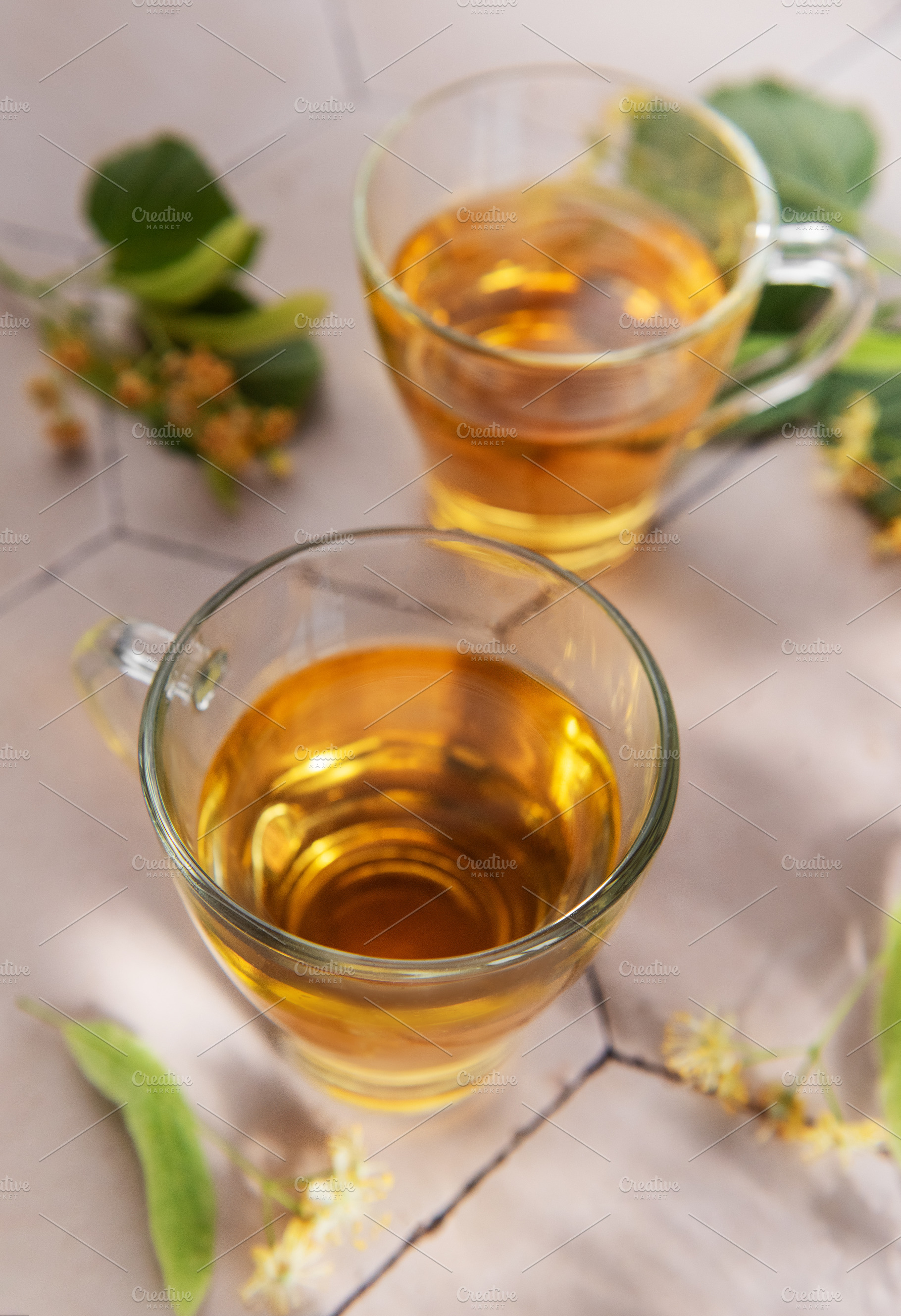 Linden herbal tea in clear cups with lime blossoms, a Food & Drink Photo by Olena Rudo