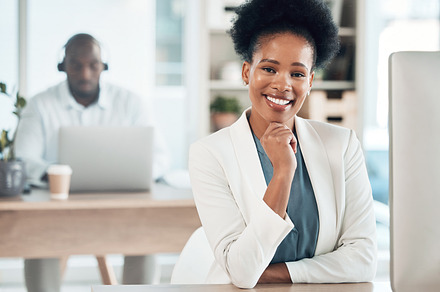 Happy, success and portrait of a businesswoman in the office with a computer working on a project. Happiness, smile and African female corporate manager sitting at her desk with a pc in workplace., a Photo by Peopleimages.com