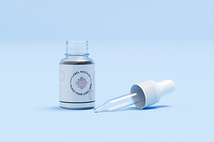 Glass dropper bottle with pipette on blue background