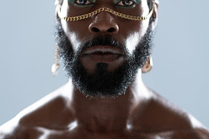 Serious African American shirtless gay model with blue eye makeup, a Person Photo by andreonegin market