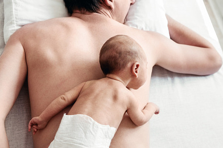 a newborn boy lies on his father's b
