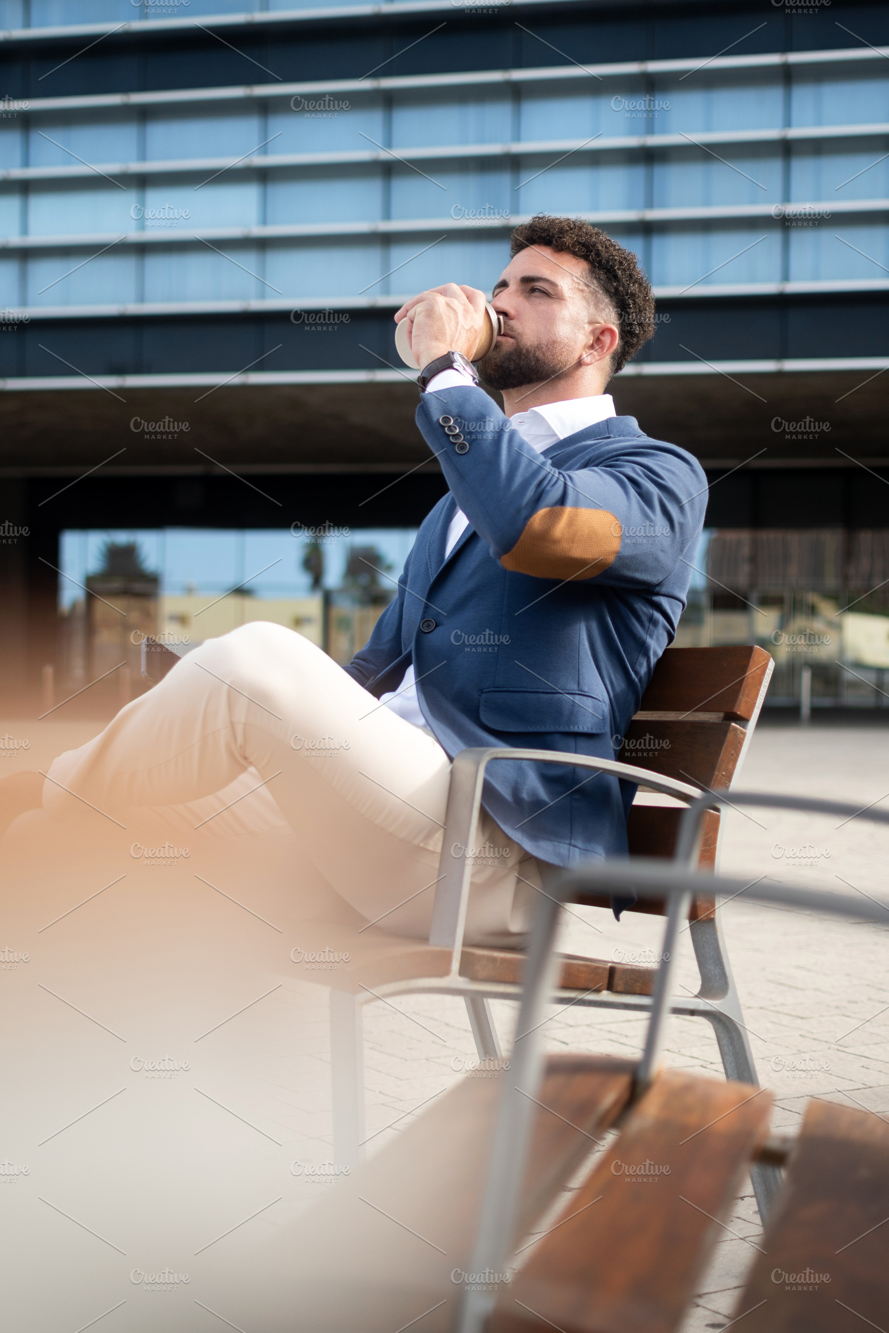 Businessman drinking takeaway coffee outside modern office, a Business Photo by etorres69