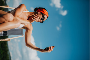 Young woman sitting by swimming pool