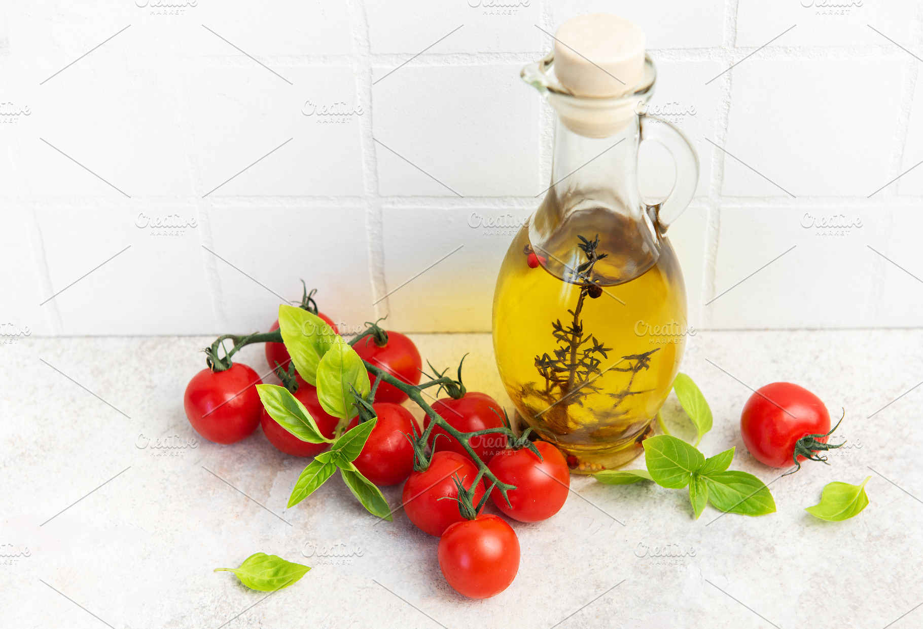 Olive oil bottle with fresh cherry tomatoes basil, a Food & Drink Photo by Olena Rudo