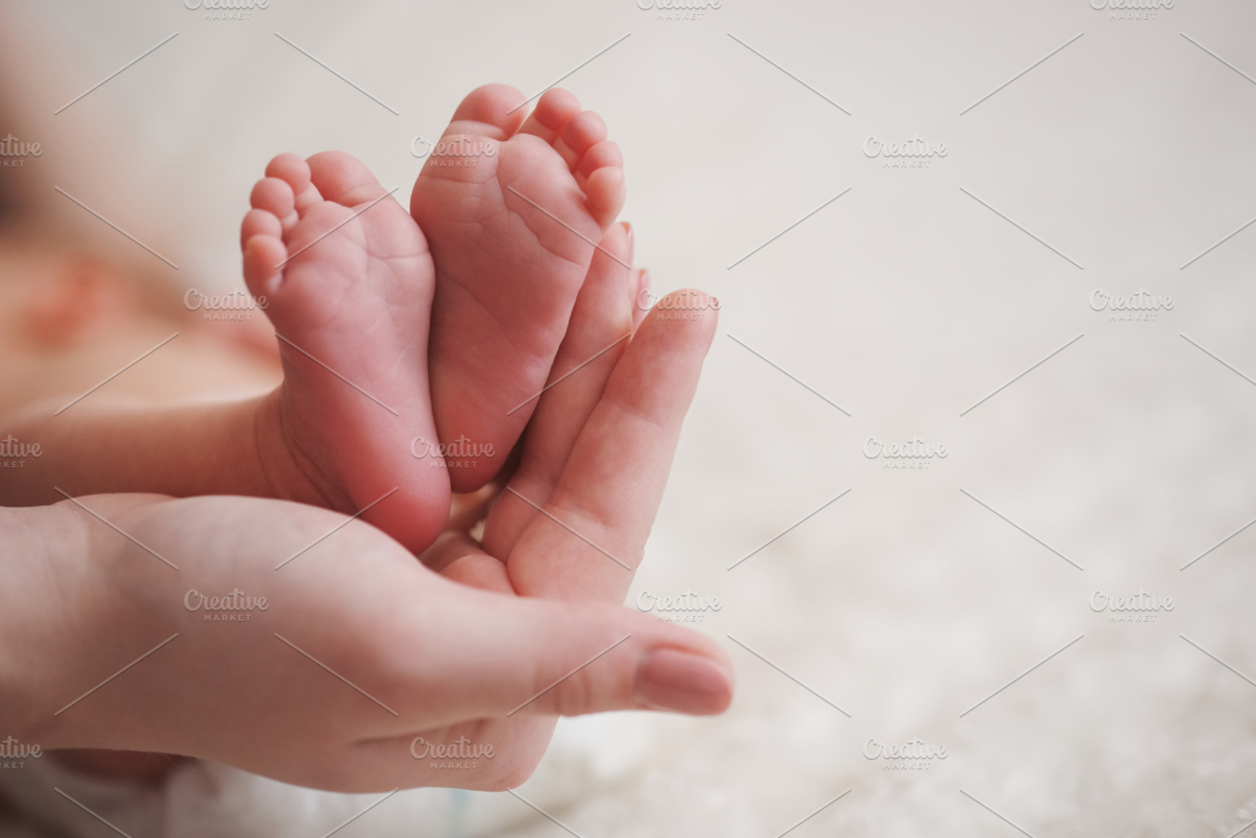 Mother holds little foot of newborn baby featuring baby, mother, and feet, a Person Photo by AlohaHawaii