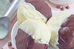 Dark and white chocolate covered ice cream sandwiches, on white plate, vertical, a Food & Drink Photo by iuliia_n