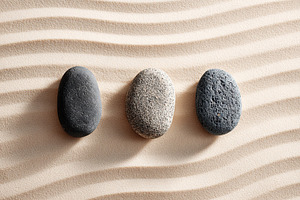 Three smooth stones on sandy surface, a Beauty & Fashion Photo by AlyaAnd