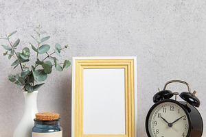 Empty photo frame, alarm clock, eucalyptus branches and jar on w, a Business Photo by Olena Rudo
