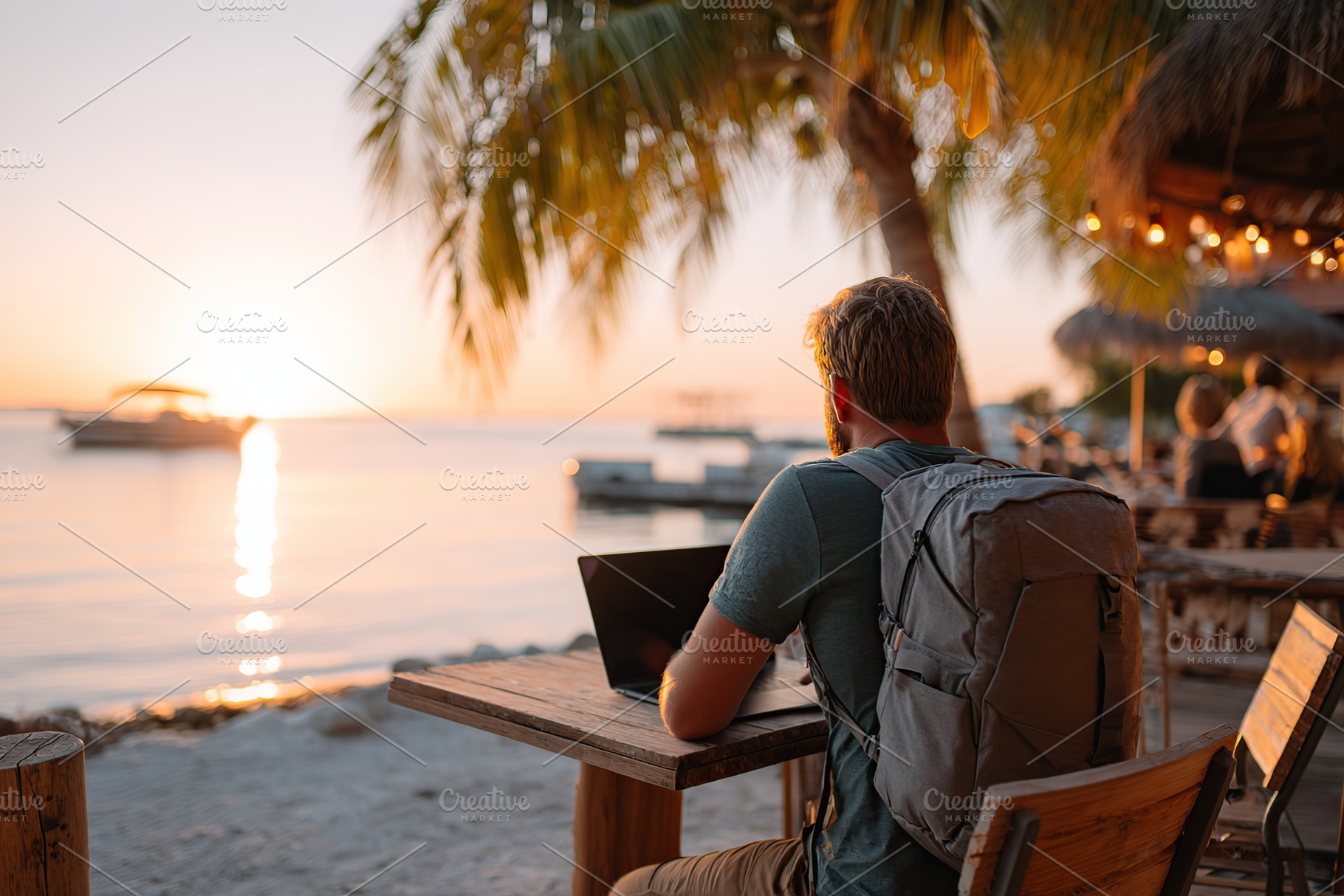 Nomad working on a laptop at sunset with a solar-powered backpack by the water, a Photo by AlyaAnd