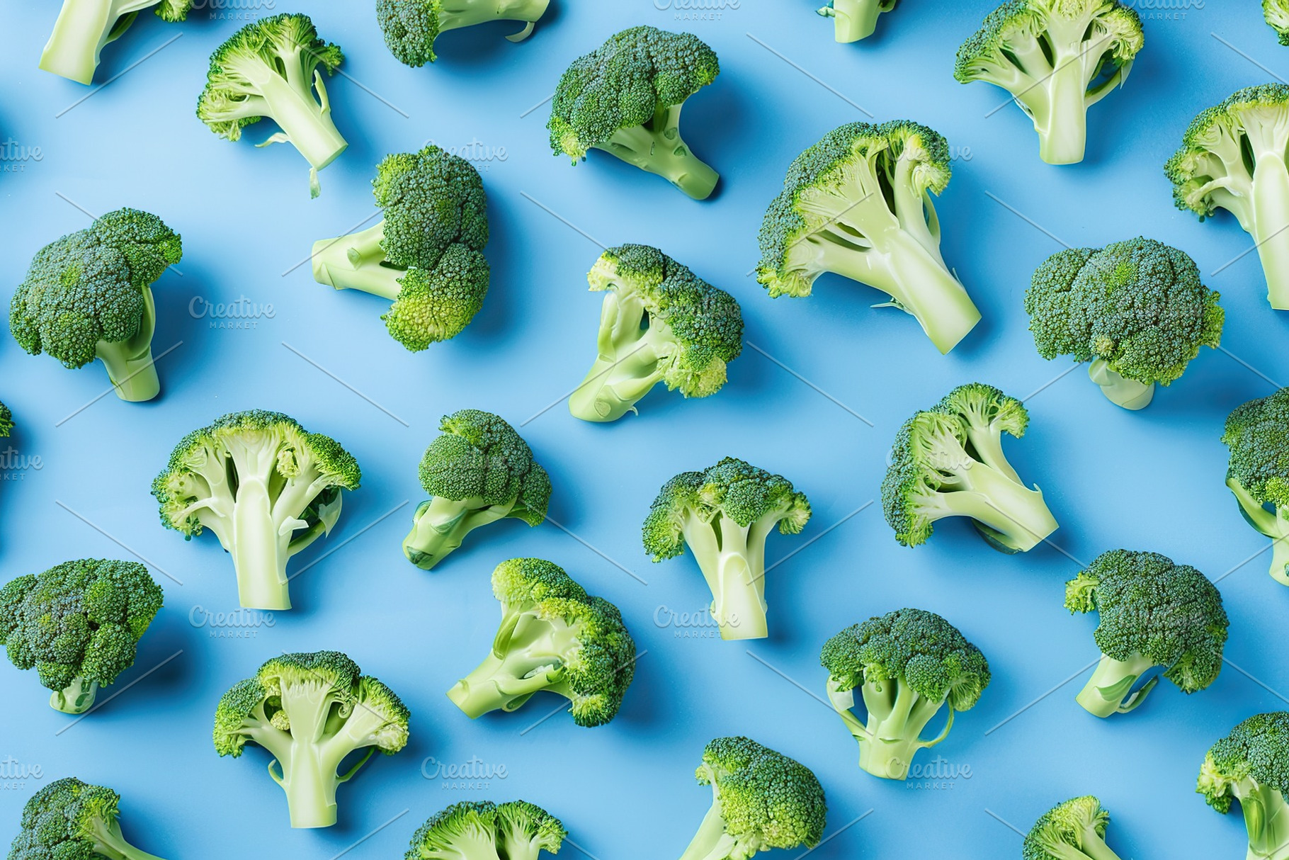 Pattern of fresh broccoli on blue background, a Food & Drink Photo by AlyaAnd