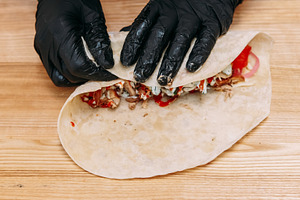Pita sandwich preparing burrito chef shawarma hand, a Food & Drink Photo by Photo Drive Studio