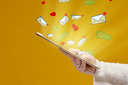 female hand holds a tablet with flying out hearts, dialogues and, a Technology Photo by ndanko