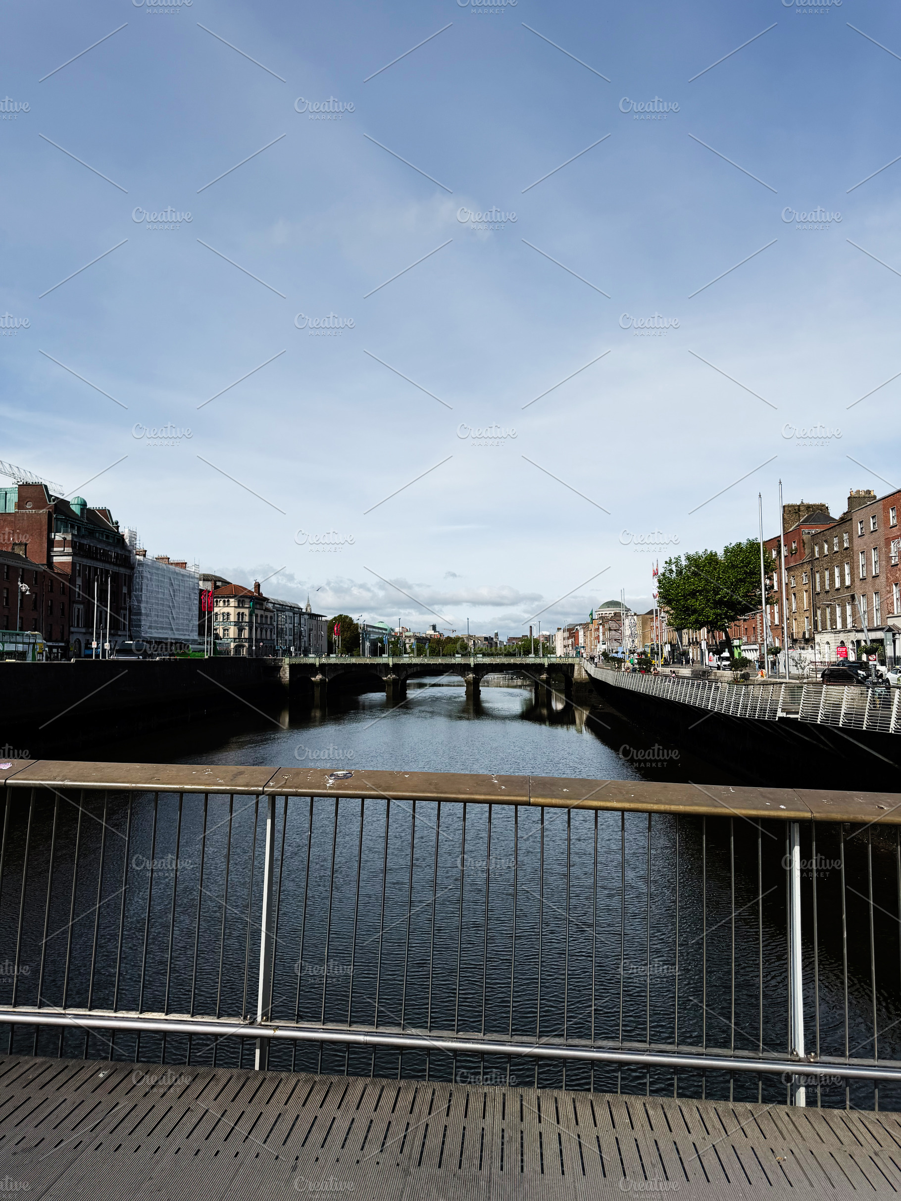 River Liffey bridge view over calm water with Dublin Ireland cit, a Photo by AS photostudio