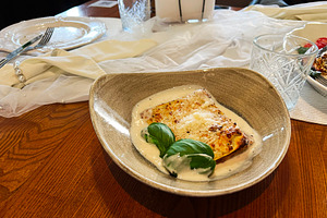 Close-up of a delicious lasagna plate served on a rustic wooden table, a Photo by AS photostudio