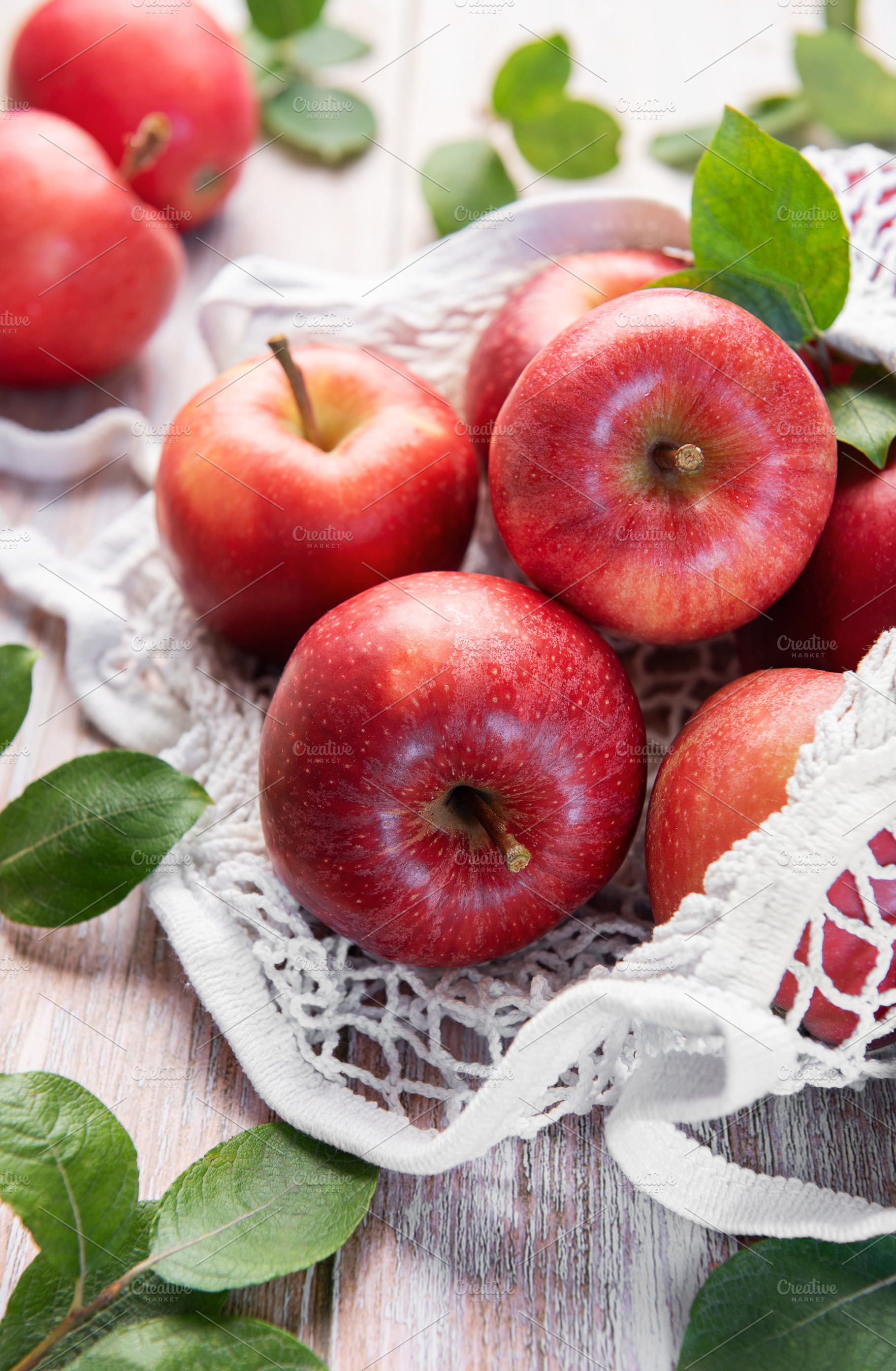Fresh red apples resting in reusable shopping bag promoting sust, a Food & Drink Photo by Olena Rudo