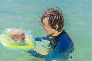 Father and newborn son swimming in, a Person Photo by Elizaveta Galitskaya