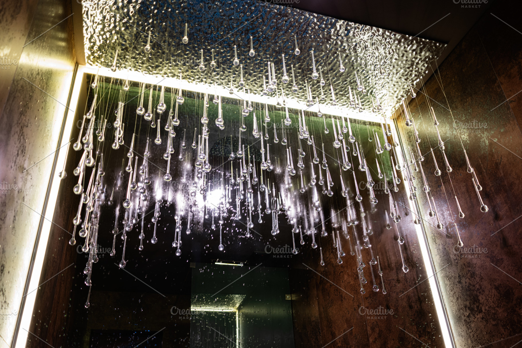 Modern ceiling with hanging glass droplets illuminated by warm lights, a Photo by AS photostudio