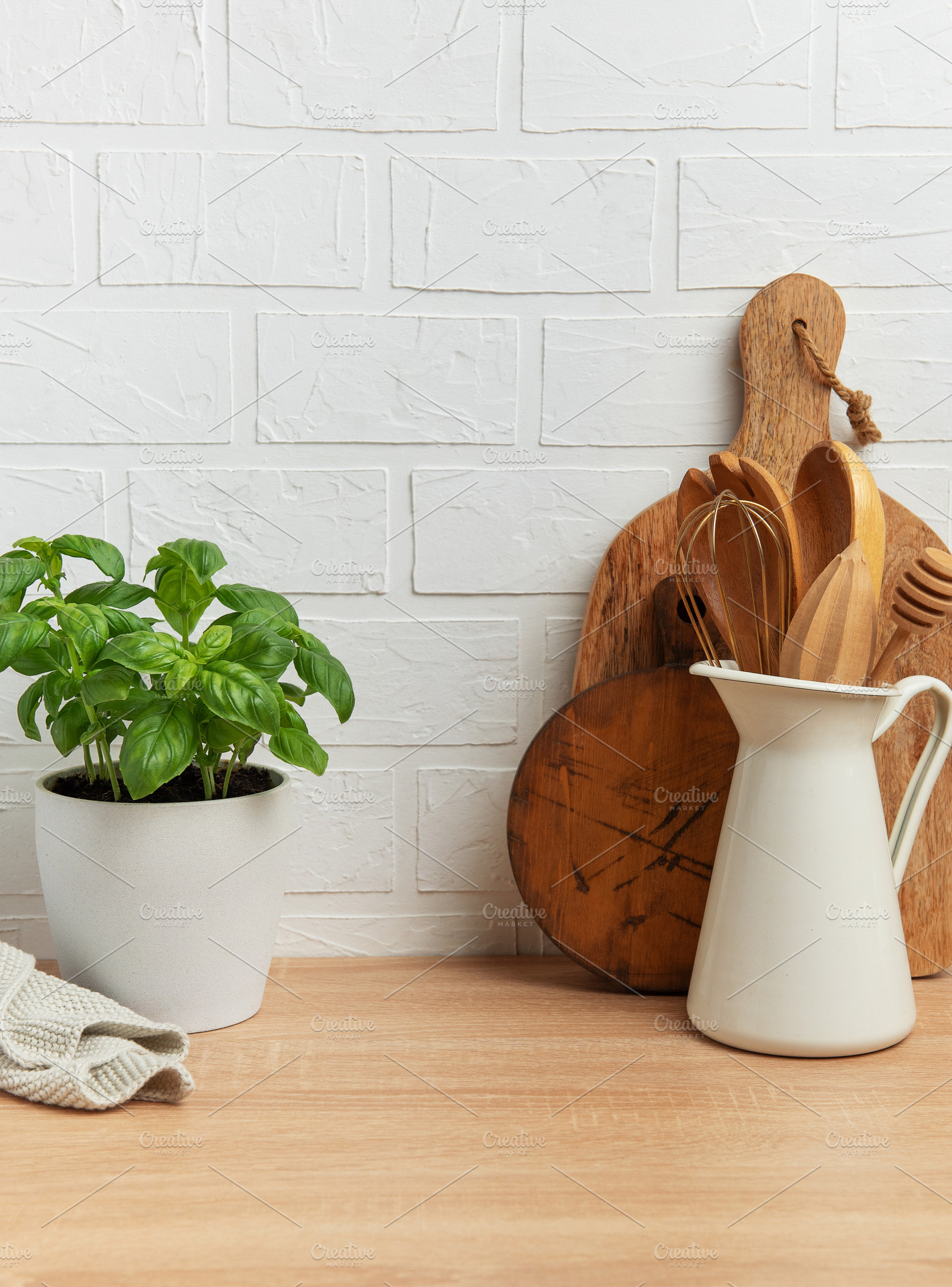Kitchen utensils and basil plant creating a rustic culinary scen, a Photo by Olena Rudo