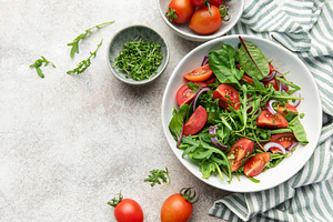 Fresh green salad with tomatoes and red onion, a Food & Drink Photo by Olena Rudo