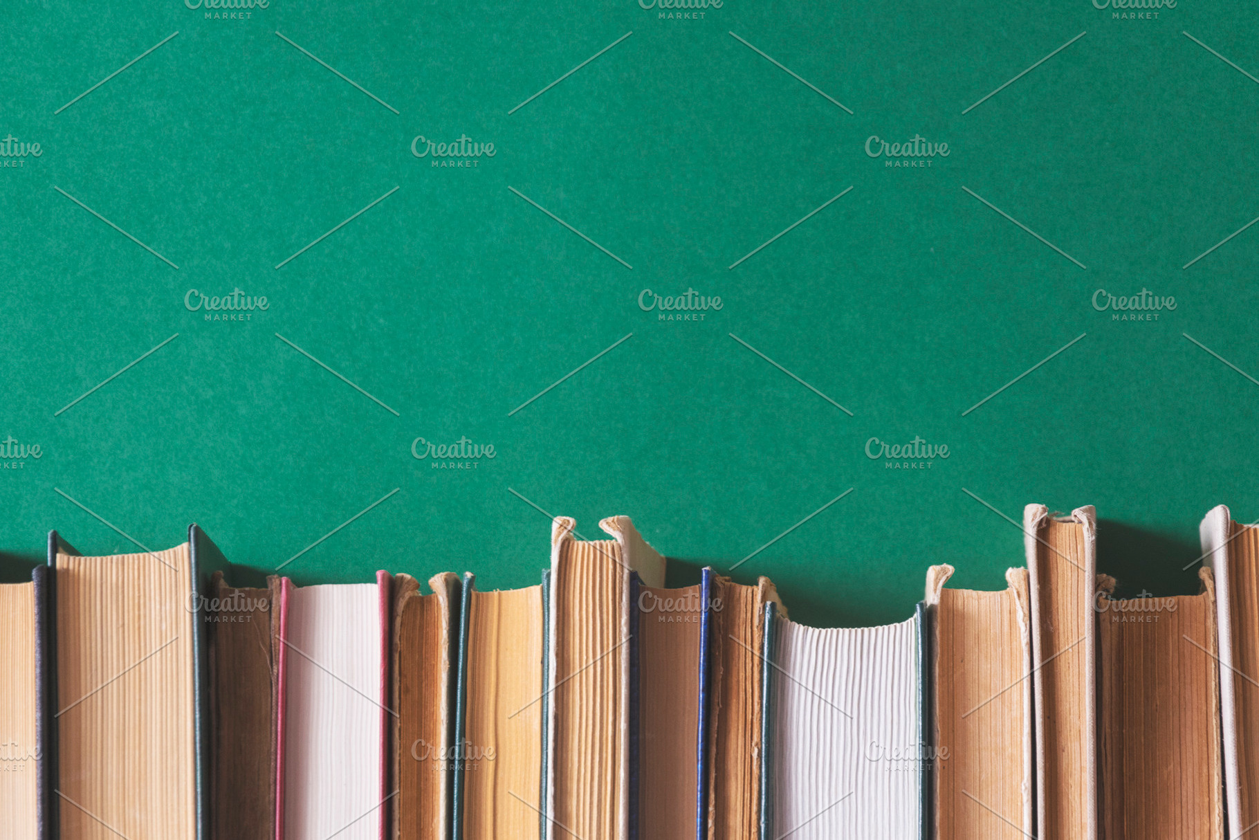 Old books on a dark green background, a Business Photo by Ti-Di