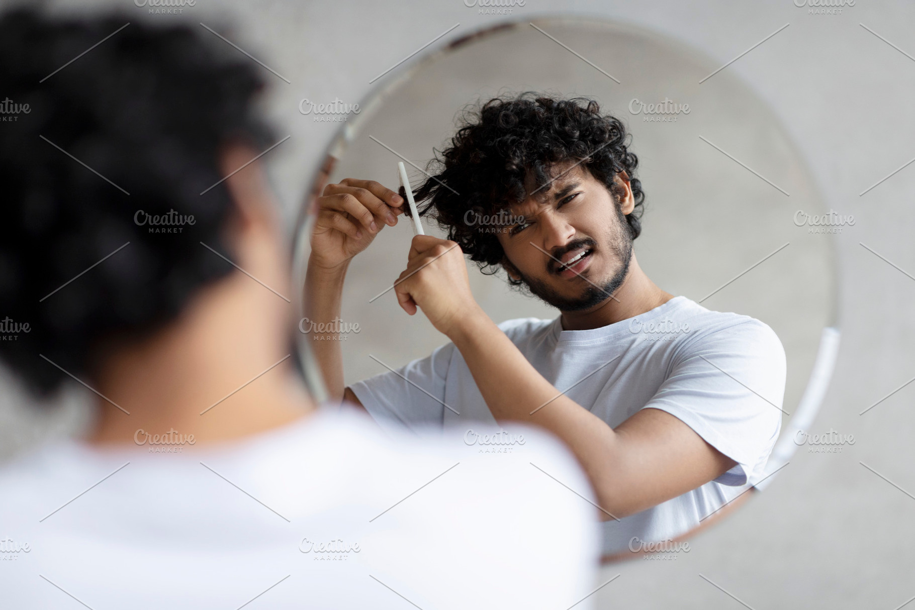 Male beauty care and hair problems. Sad indian man in white t-shirt can't comb, a Person Photo by Prostock-Studio