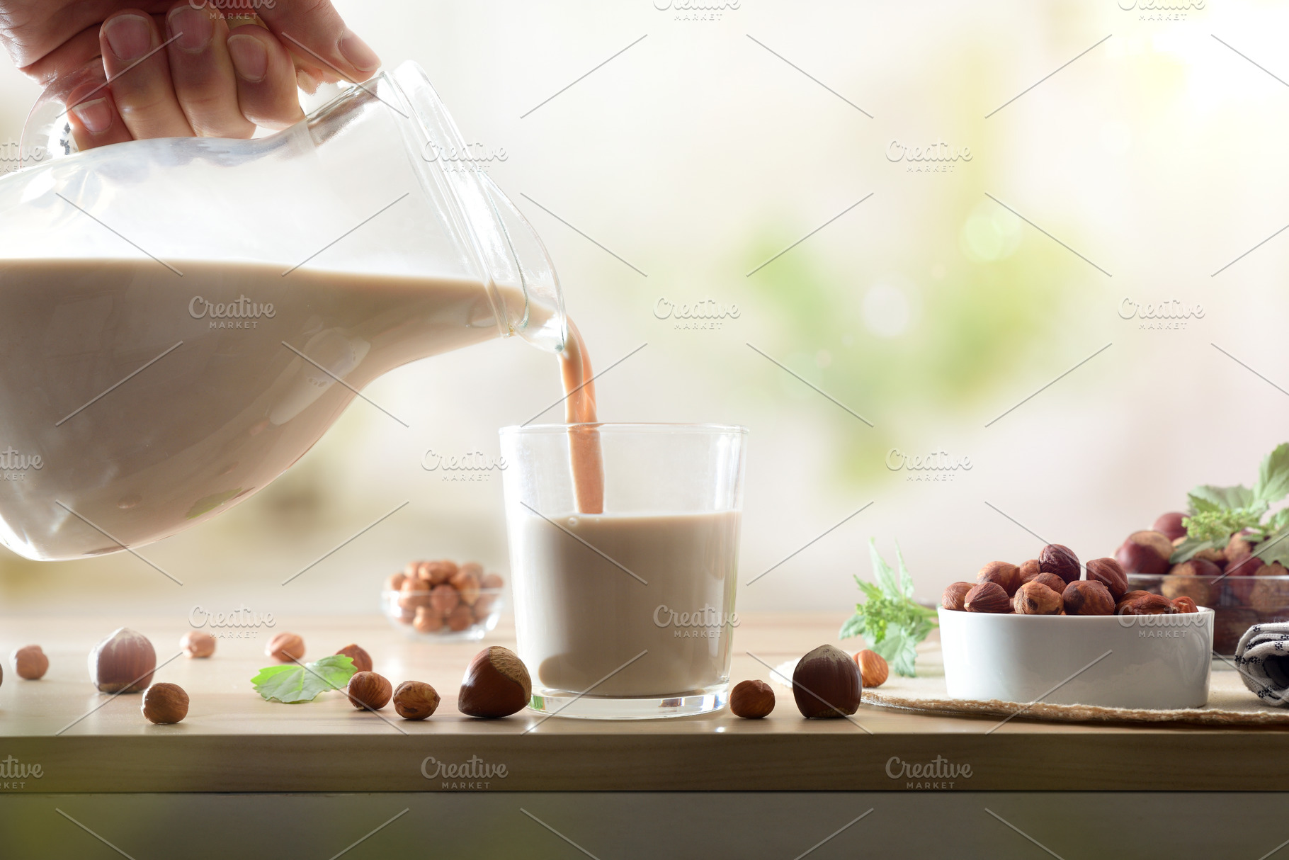Filling glass with hazelnut drink on wooden kitchen bench, a Food & Drink Photo by Davizro's Market