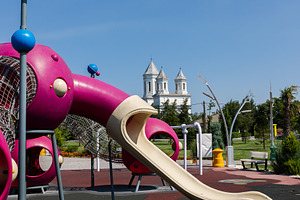 Colorful playground with slides and climbing structures in a park, featuring a, a Sports & Recreation Photo by Ales Munt
