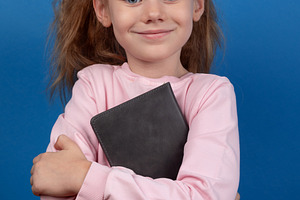 Smiling Girl Holding Book, a Person Photo by Ales Munt