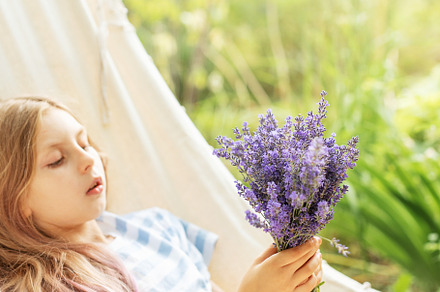 A little girl rests in a hammock  in the summer., a Person Photo by Olena Rudo