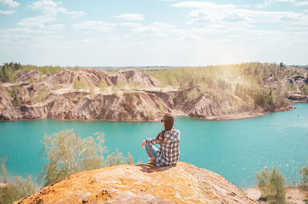 Young woman sitting on the top of mounting and feeling free and looking at the, a Person Photo by travnikovstudio