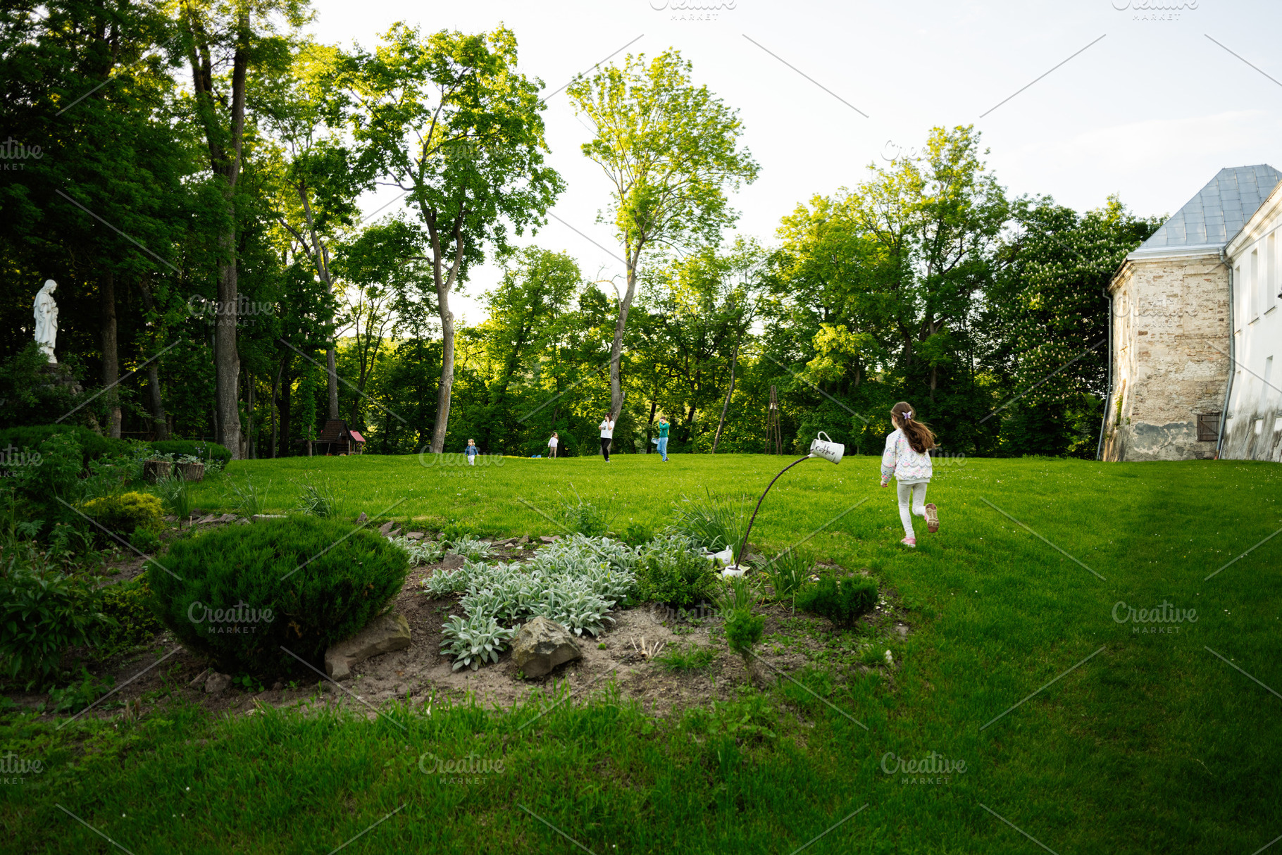 Children playing on a grassy hill amidst trees and natural surroundings, a Photo by AS photostudio
