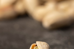 pistachios with green nuts inside, the salted pistachios on the table, a Photo by rsoollAI