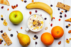 Healthy breakfast with milk, cereals, fruits and energy bars on white wooden ta, a Food & Drink Photo by Antonio Gravante Market