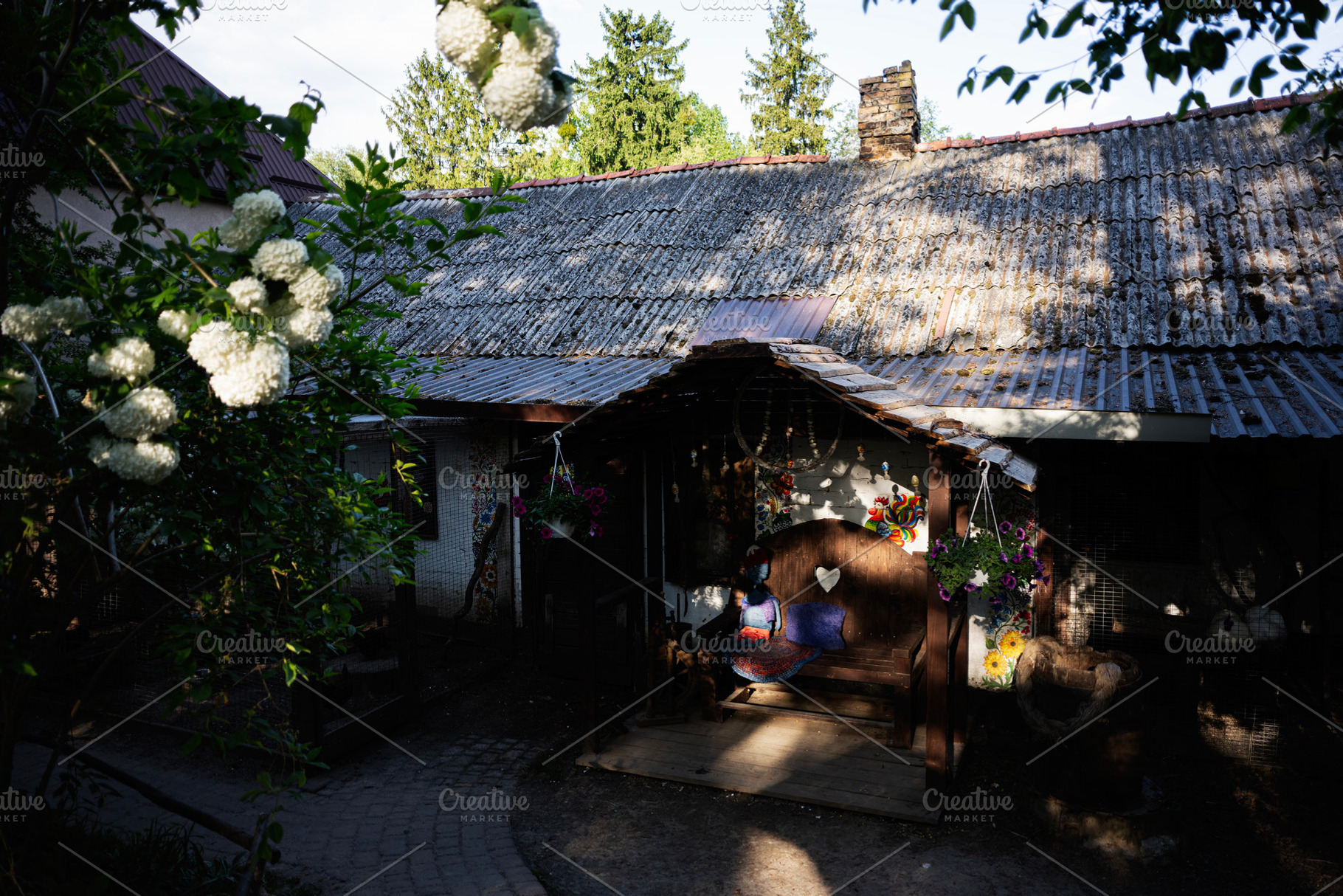 Rustic rural home with decorative elements in a tranquil garden setting, a Photo by AS photostudio