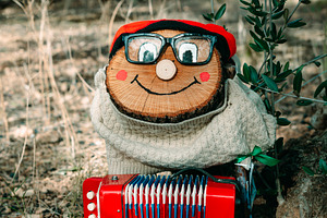 a Tio de Nadal standing with a red accordion, a Photo by Nito