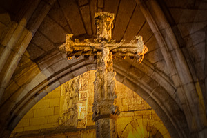Stone cross under gothic arch inside medieval chapel, a Photo by DanFLCreativo