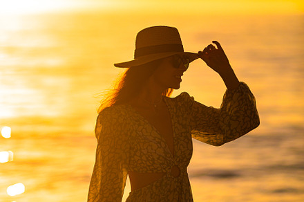 Young beautiful woman at straw hat on the beach at sunset, a Person Photo by travnikovstudio