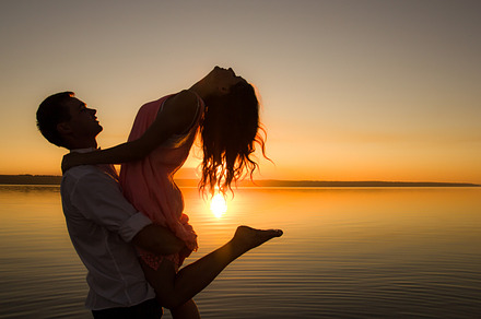 Young couple is dancing in the water containing background, beach, and