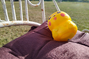 Playful yellow toy on chair in sunlit garden, an Arts & Entertainment Photo by DanFLCreativo
