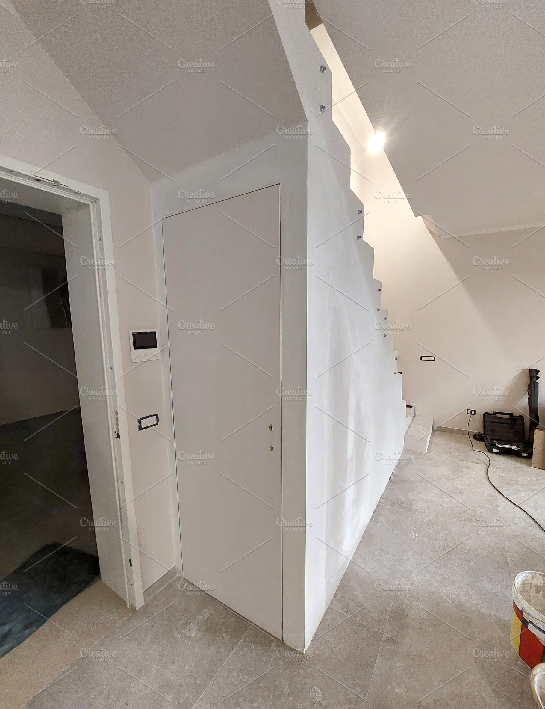 White flush to wall door under staircase during renovation, an Architecture Photo by Antonio Gravante Market