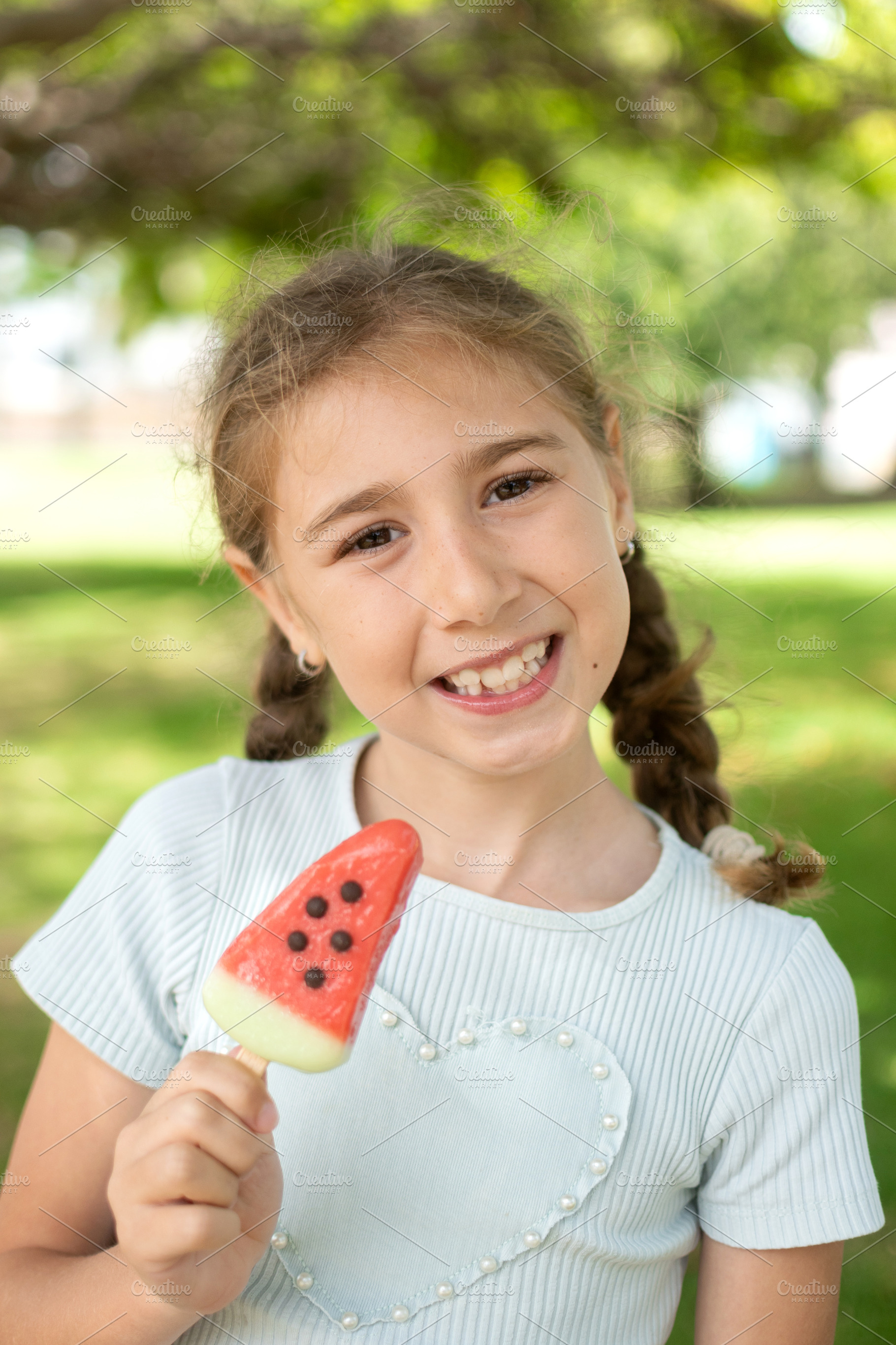 Smiling Little Girl Holding a Watermelon Popsicle, a Person Photo by etorres69