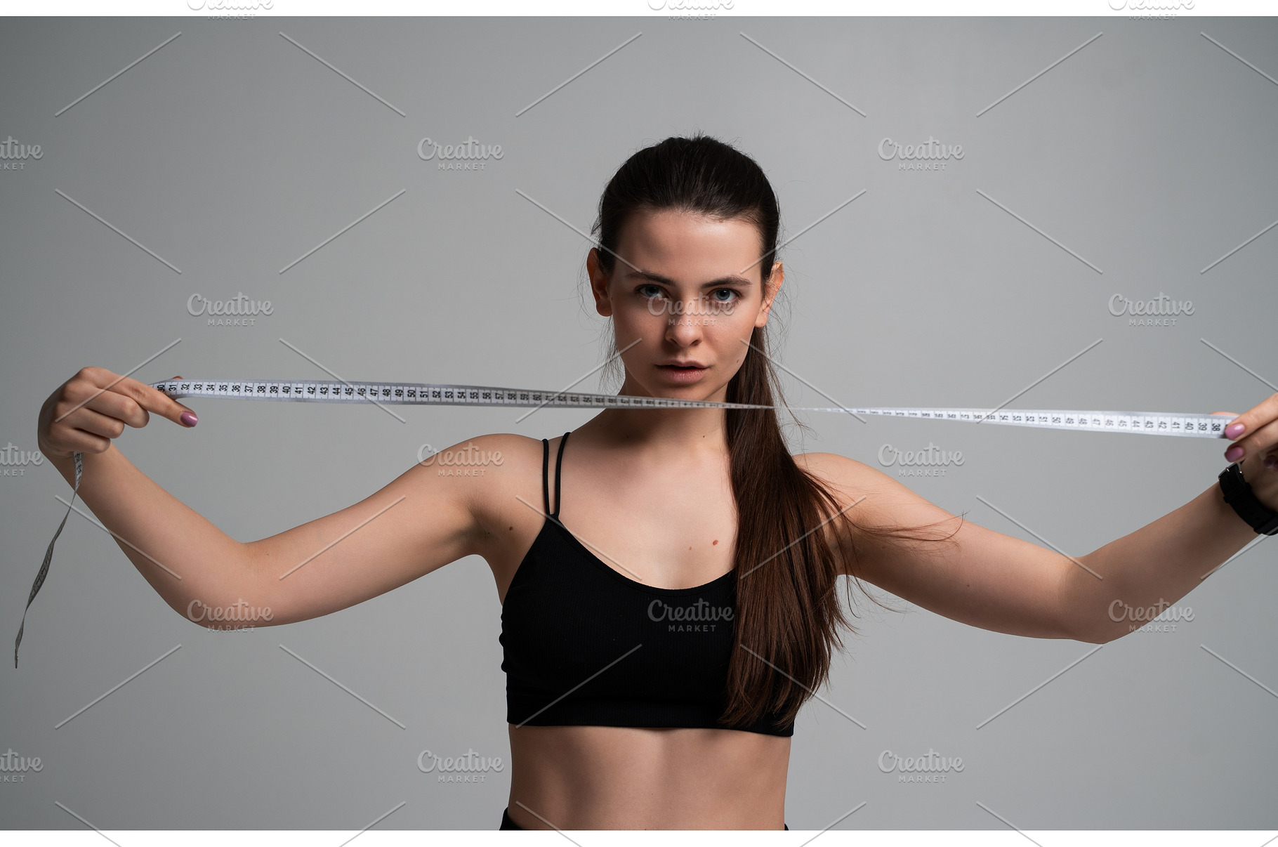 Young woman holding a measuring tape, a Sports & Recreation Photo by volodymyrshtun13795