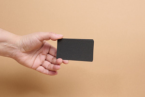 A person holding a stack of black business cards against a beige, a Business Photo by ndanko