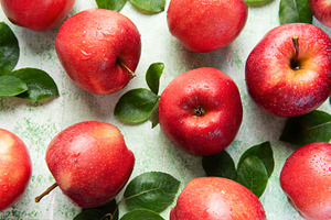 Fresh red apples with green leaves creating appealing pattern on, a Food & Drink Photo by Olena Rudo