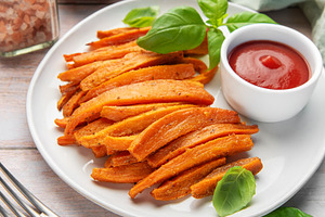 Sweet potato fries with ketchup and fresh basil leaves, a Food & Drink Photo by Olena Rudo