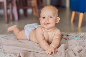 Baby lying on play mat learning to, a Background Photo by Elizaveta Galitskaya