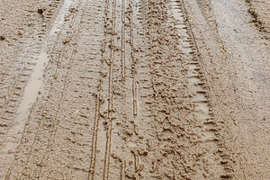 Dirty road after rain with car marks