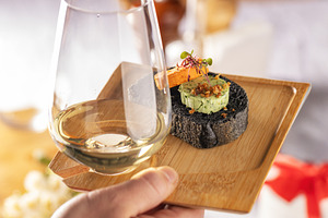 Waiter serving a glass of white wine and black bread canapes, a Photo by Grafvision photography