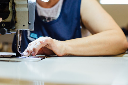 Woman sews leather piece
