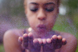 A woman blowing glitter